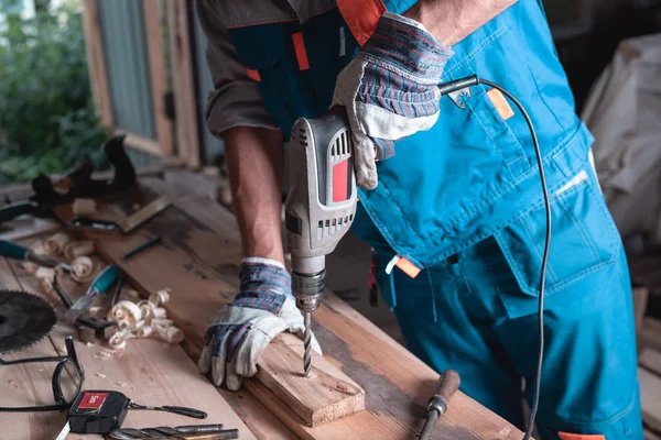 Laboratorio Domestico Uomo Costruttore Tuta Guanti Trapana Una Tavola Legno — Foto Stock