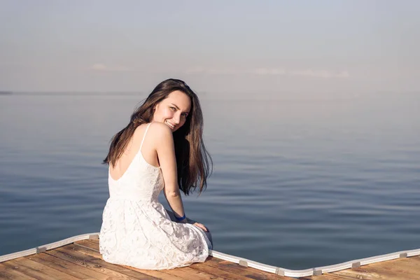 Mujer Sentada Muelle Por Mitad Sonriendo Vestido Blanco Sobre Fondo — Foto de Stock