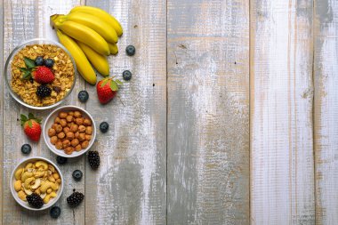 Meyve ile ev yapımı granola fındık ahşap arka plan üzerinde meyveleri. Görünümü en çok, uzay kopyalayın. Sağlıklı gıda kavramı.