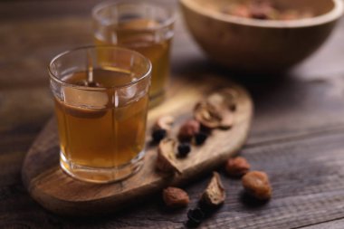 Cam bardak kuru meyve kompostosu, yakın çekim ve çeşitli ahşap oyun tahtası ahşap bir kase. İçki çeşitli. Seçici odak.