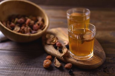 Dried fruits cam bardak ve karışık Kuruyemiş rustik ahşap zemin üzerine ahşap kase Komposto. Seçici odak.