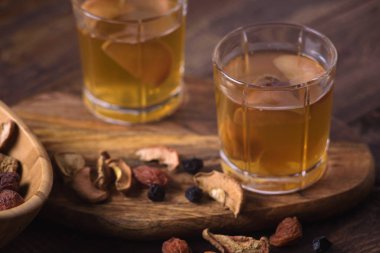 Cam bardak ahşap arka plan üzerinde kurutulmuş meyve kompostosu