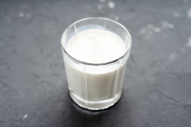 gri arka plan cam bardakta süt close-up. Süt ürünleri