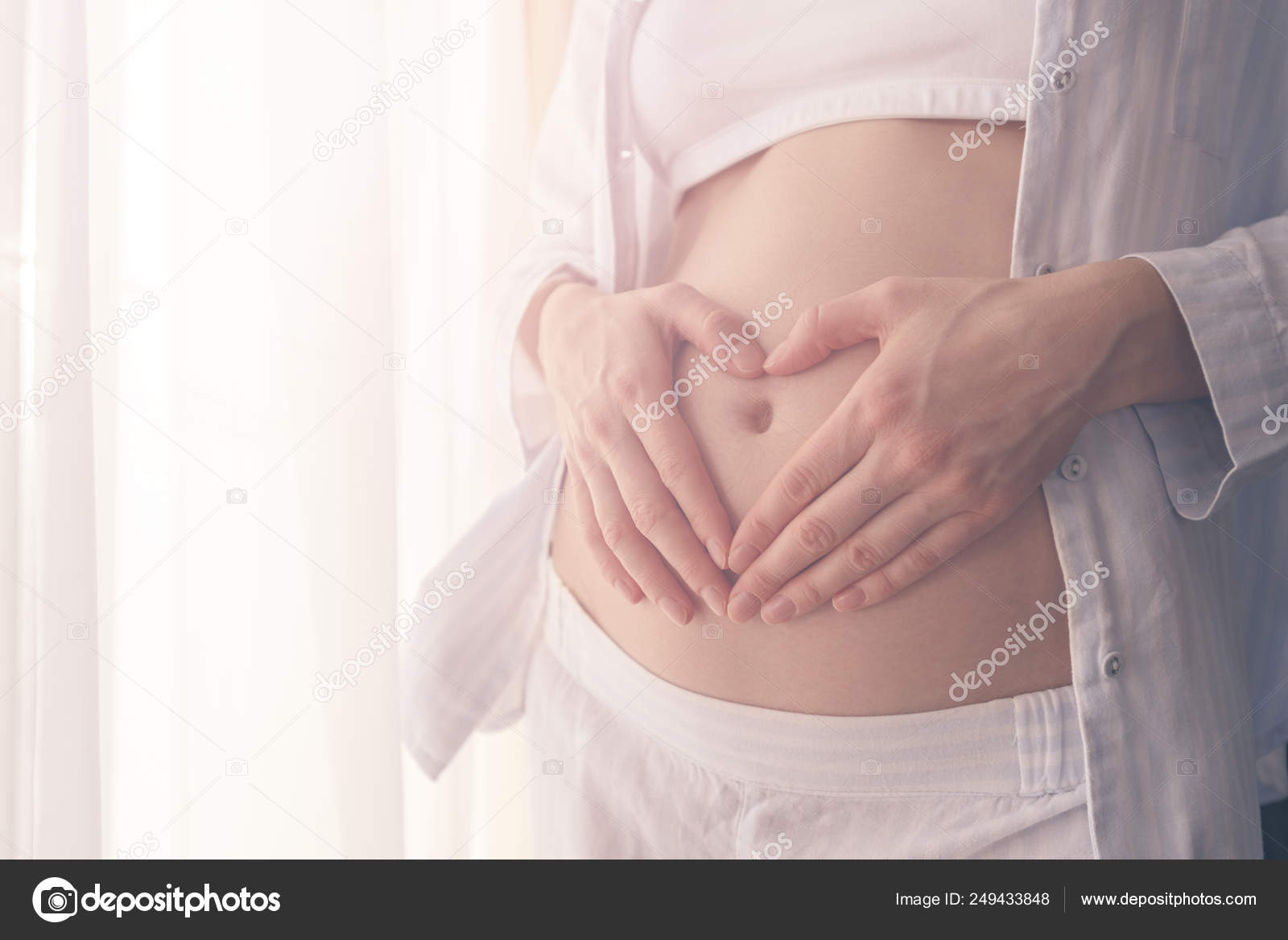 お腹にハートの形に手で妊娠中の女の子 ストック写真 C Rasselbor