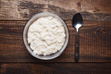 kahverengi ahşap zemin üzerine kaşık yulaf ezmesi