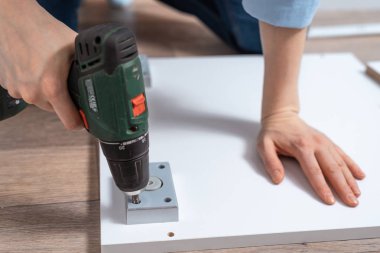 bir kadın bir tornavida yakın çekim, mobilya montaj kullanarak mobilya parçası katlanmış