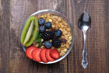 kahverengi ahşap arka planda çilek ve kivi ile müsli