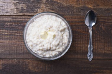 koyu kahverengi ahşap arka planda kaşık ile yulaf ezmesi