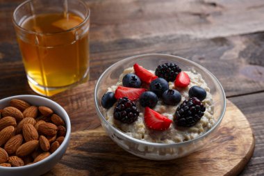 çilek ve badem ile yulaf ezmesi, ahşap arka planda komposto cam