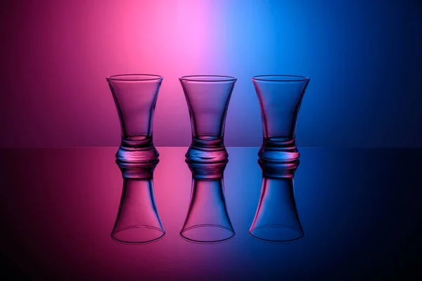 Three empty shots on pink and blue background — Stock Photo, Image