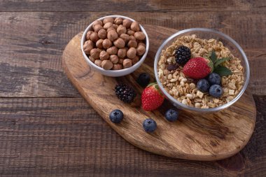 Granola fındık ve ahşap arka plan üzerinde meyveleri ile. Sağlıklı kahvaltı.