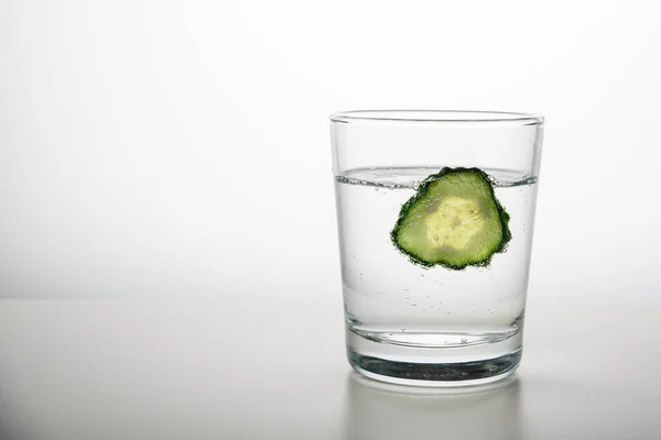 glass of cucumber water on white background with copy space