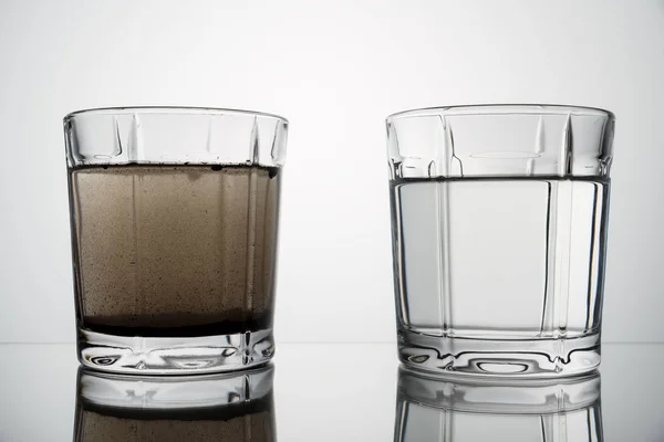 Cerrar vasos con agua limpia y sucia — Foto de Stock