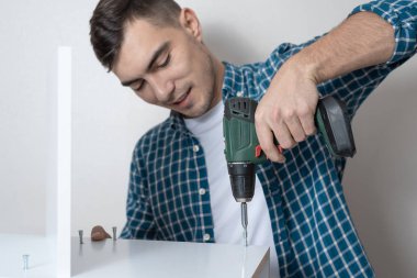 Beyaz adam bir tornavida ile mobilya montajı