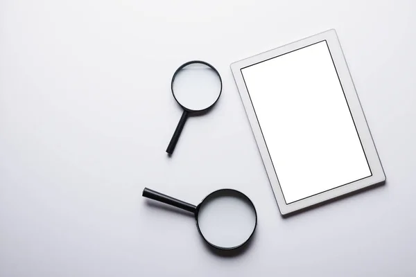 Vista superior do comprimido, duas lentes de ampliação sobre fundo branco com espaço de cópia. conceito de pesquisa na Internet — Fotografia de Stock