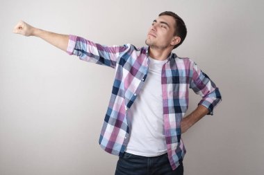 Beyaz bir t-shirt ve bir süper kahraman olarak poz renkli bir gömlek genç bir adam