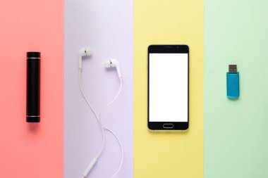 sanat tasarım kavramı gadgets. akıllı telefon, güç Bankası, kulaklıklar, çok renkli çizgili arka planda Flash sürücü