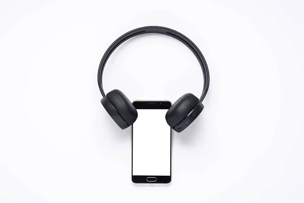 Minimalistiskt koncept av prylar för musik älskare, smartphone med vit skärm med trådlösa hörlurar. layout för appar — Stockfoto