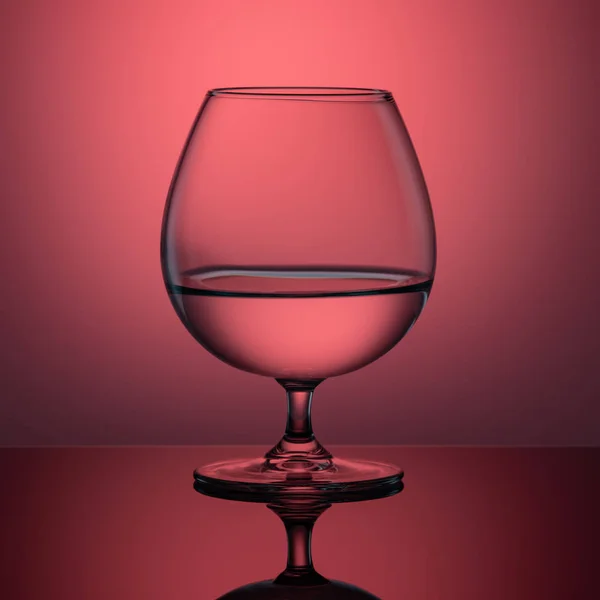 Glass Cup on the table pink lighting — Stock Photo, Image