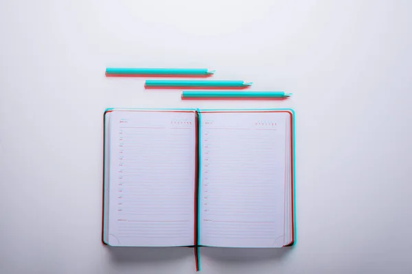 Vista superior de un cuaderno abierto con lápices, anaglifo y efecto de fallo técnico — Foto de Stock