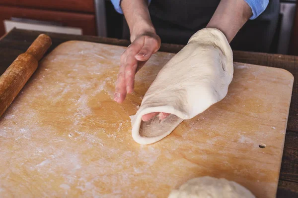 Women\'s hands roll out pizza dough close-up
