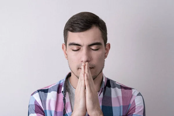 Hombre europeo de cerca rezando con las manos cruzadas delante de su cara —  Fotos de Stock