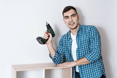 Elinde elektrikli tornavida ile genç bir güzel Avrupalı adam portresi, mobilya bir koleksiyoncu. kopyalama alanı