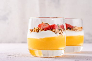 mango smoothie, ricotta, midye ve çilek parçaları tatlı Panna cotta ile frontal iki bardak