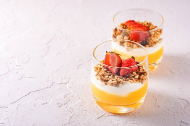 Mango smoothie, Yunan yoğurt, granola ve fotokopi alanı ile çilek yapılmış vejetaryen tatlılar ile iki cam bardak