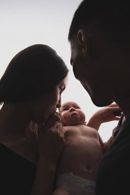 Birbirine yakın duran yeni doğmuş bir bebek ile bir aile portresi yakın çekim siluet