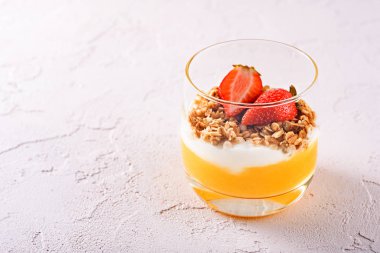 mango smoothie, ricotta, müsli ve çilek yapılmış vejetaryen tatlı bir bardak üst görünümü