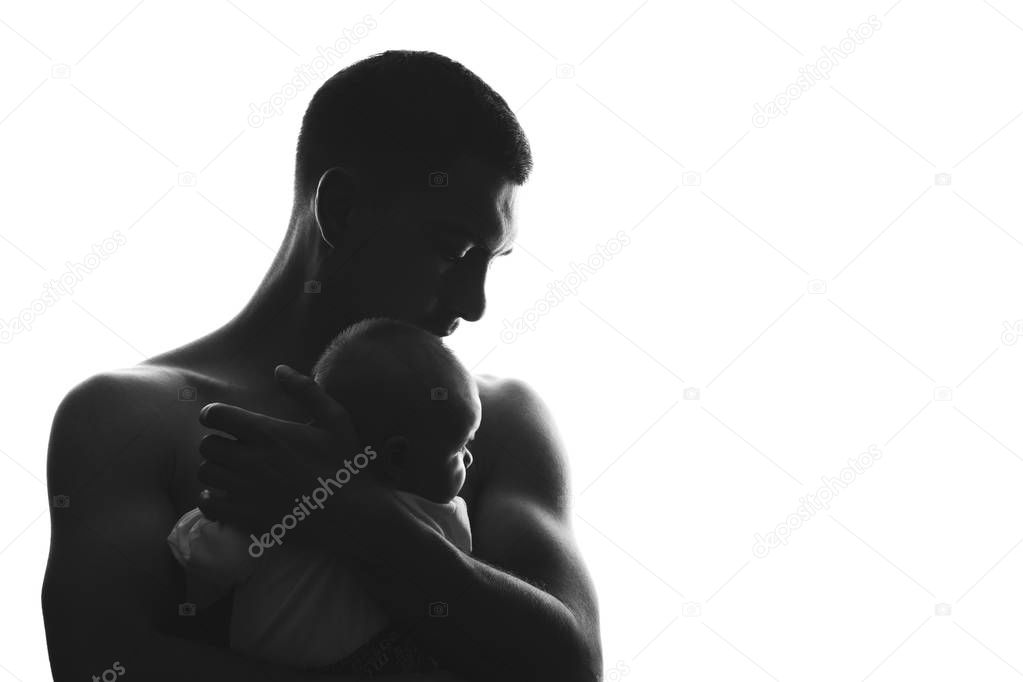 Silhouette of a father man with a naked torso with a newborn baby in his arms in an embrace, paternity, art concept