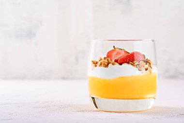 Mango smoothie, ricotta, midye ve çilek yapılmış vejetaryen tatlı bir bardak ön görünümü