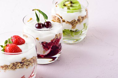pembe arka planda ricotta, granola, çilek, kivi ve kiraz ile tatlılar çeşitli