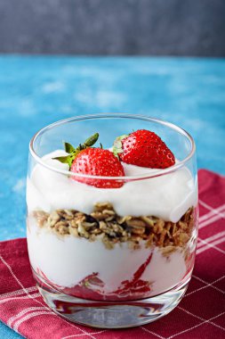 mavi gri arka plan üzerinde çilek, granola ve lor mus ile tatlı dikey görüntü