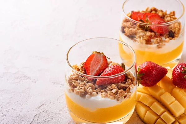 mango smoothie, ricotta peyniri, granola ve çilek güzel dilimlenmiş mango ve pembe arka plan üzerinde kopya alanı meyve tatlı ile iki bardak yakın çekim