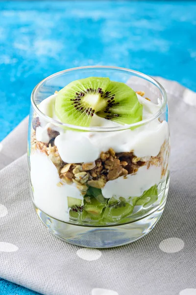 mavi arka plan üzerinde kivi, granola ve lor mus ile tatlı