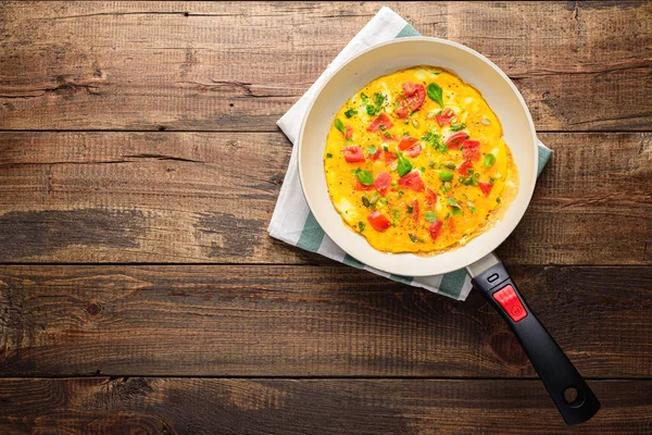 Omelete com tomates e ervas no estilo rústico em chapa. Frittata - omelete italiano . — Fotografia de Stock