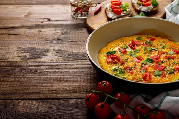 kopya alanı ile koyu ahşap arka plan üzerinde sebze ve kiraz domates ile omlet