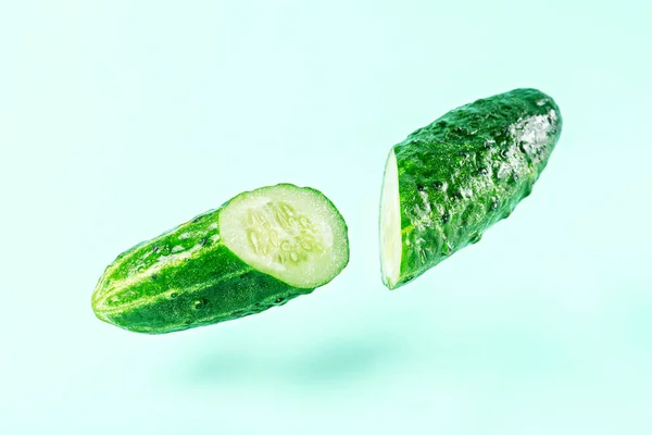 sliced cucumber on blue background with levitation effect, art vegetable concept