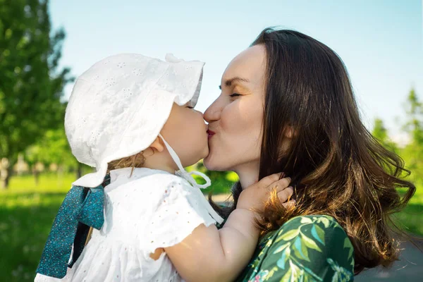 mom and daughter kissing, unconditional love, happy motherhood, childhood summertime