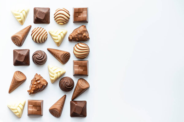 chocolate candies on white background, copy space, top view, space for text, world chocolate day concept