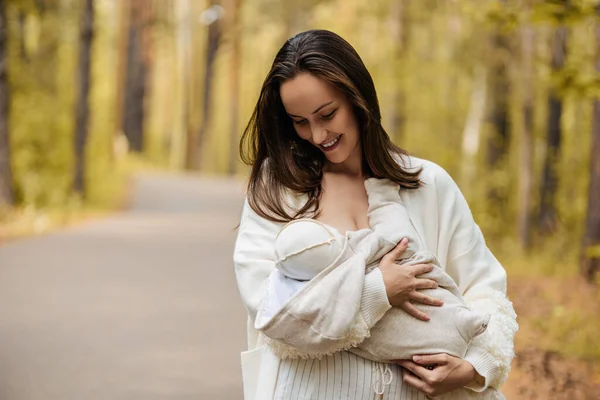 Beyaz Ceketli Genç Mutlu Anne Ormanda Kucağında Bebek Olan Kadın — Stok fotoğraf