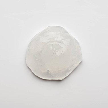 Beyaz arka planda şeffaf jel lekesi, kozmetik krem, üst görünüm