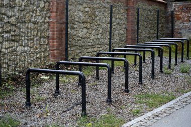 Şehir ortamında metal bisiklet parkında sıra sıra. Sürdürülebilir hareketlilik, ulaşım ve şehir altyapısının sembolü. Modern şehir arkaplanı.