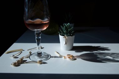 Masanın üzerinde inci bulunan zarif ve göz alıcı mücevherler bir bardak pembe ya da kırmızı şarap, romantizm.