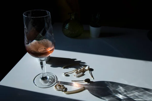桌上放着精致迷人的珍珠珠宝 桌上放着一杯粉色或红酒 浪漫极了 — 图库照片