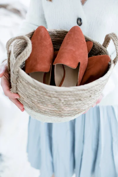 fashionable womens shoes without heels, mules and loafers, on female legs, a girl in a dress and shoes, resting at home in the bedroom, reading a magazine, trending shoes for advertising, in a basket