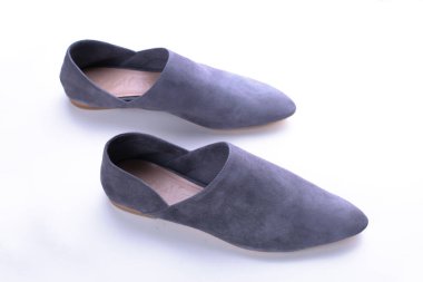 Kentsel gri mokasenler, modern gündelik kadın ayakkabıları, klasik süet katırlar ve mokasenler, deri ikame, beyaz arka planda şık bir stüdyo,