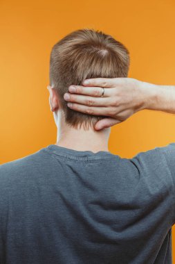 stüdyoda genç adamın kafa dokunmadan arka görünümü